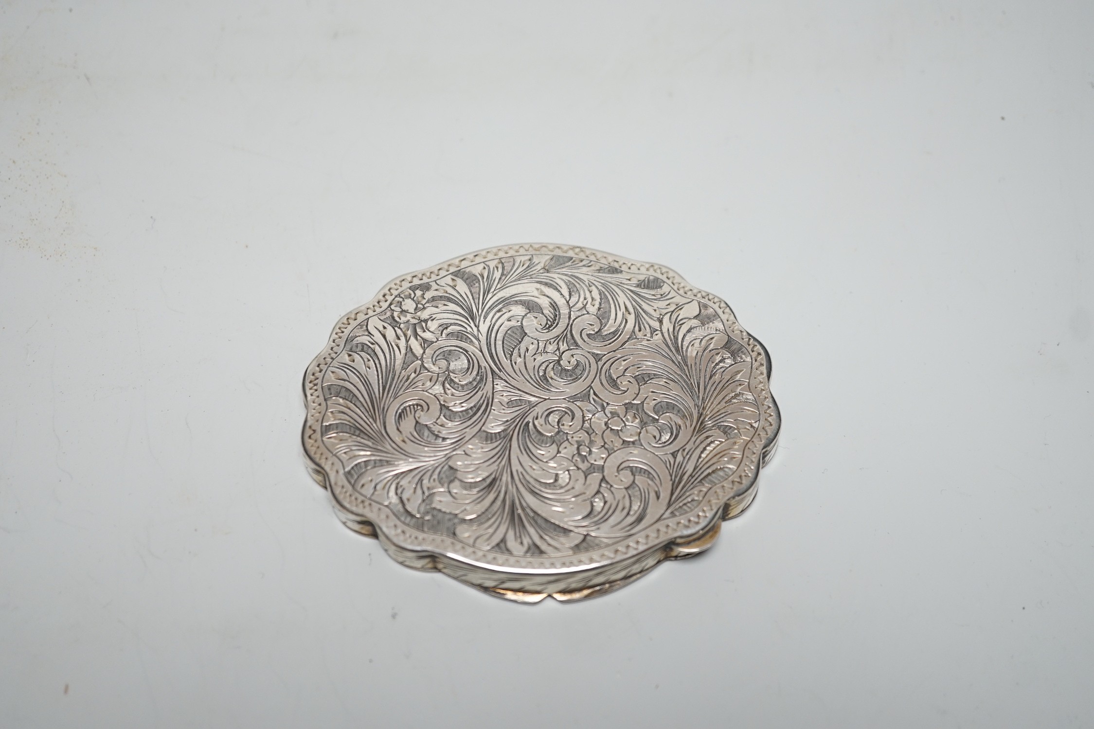 An early 20th century Austro-Hungarian? 800 standard white metal and polychrome enamelled cusped oval box and cover, the cover decorated with lady and gentleman at leisure, 97mm.